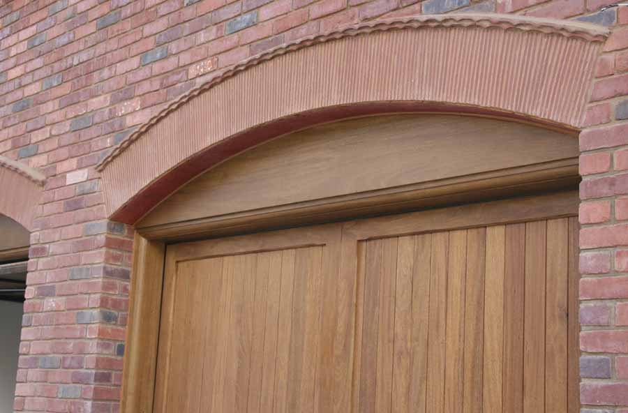 a combination of plain tiles and creasing tiles add detail above these garage doors